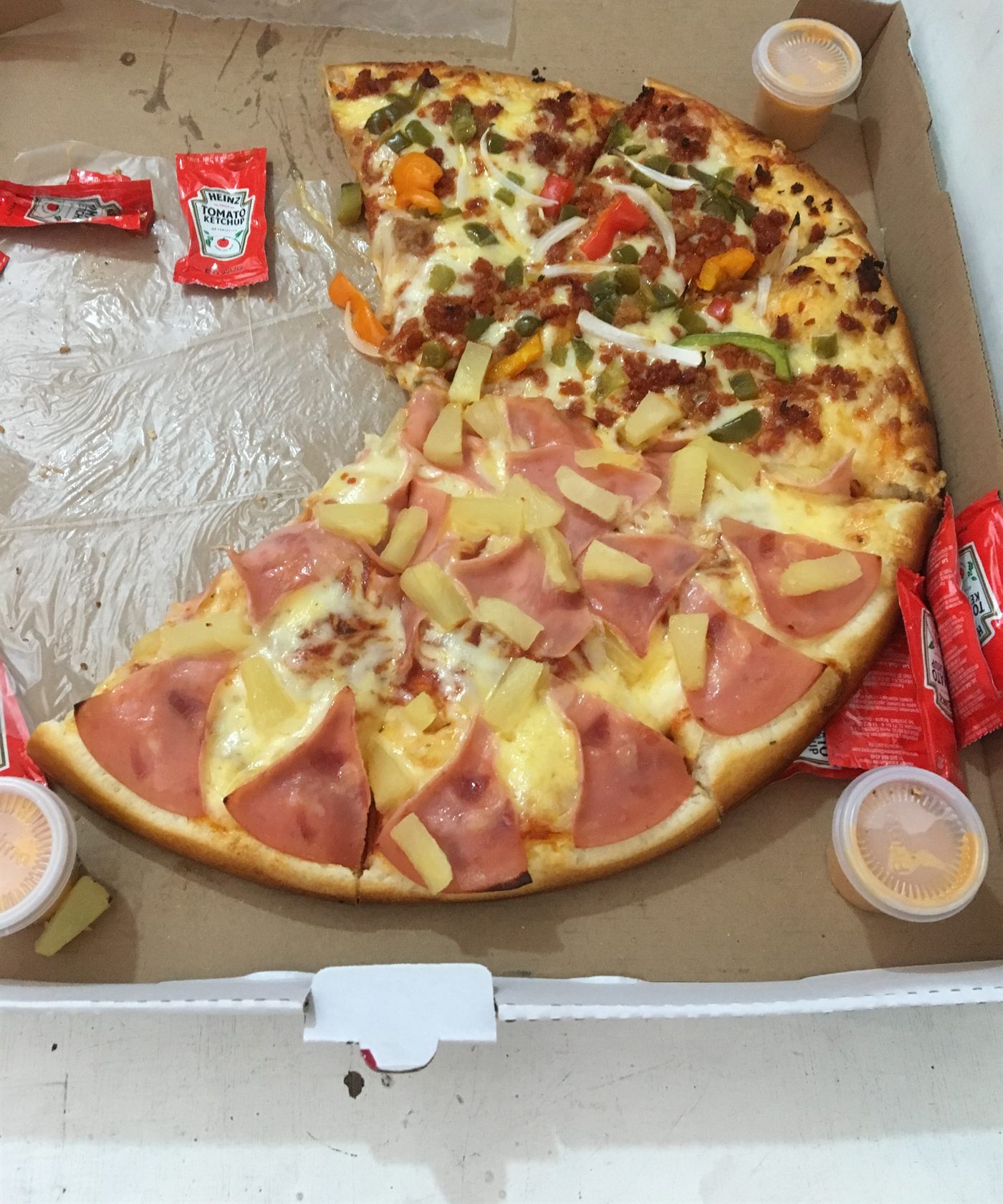 Pizza hawaiana de jamón y piña servida en su caja