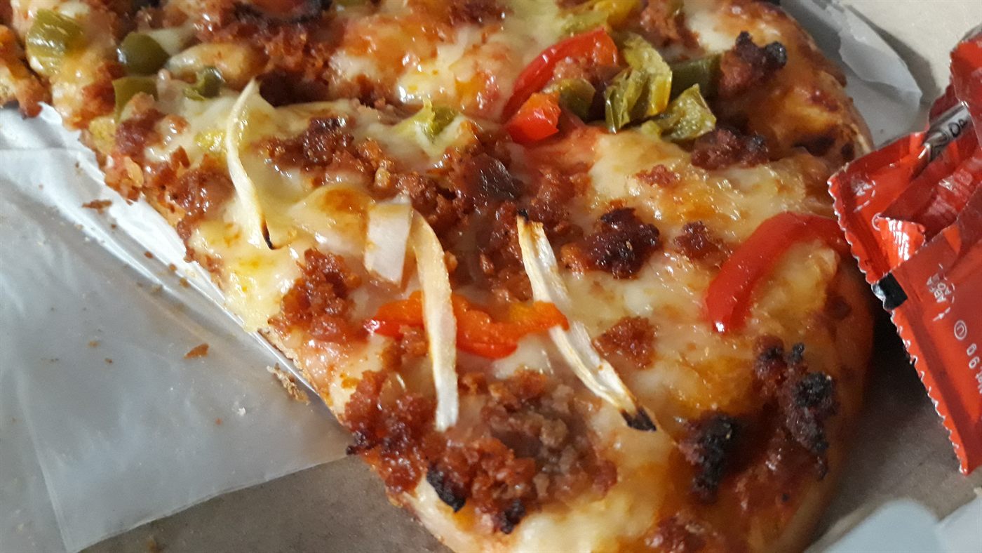 Acercamiento de una pizza de carnes con queso derretido