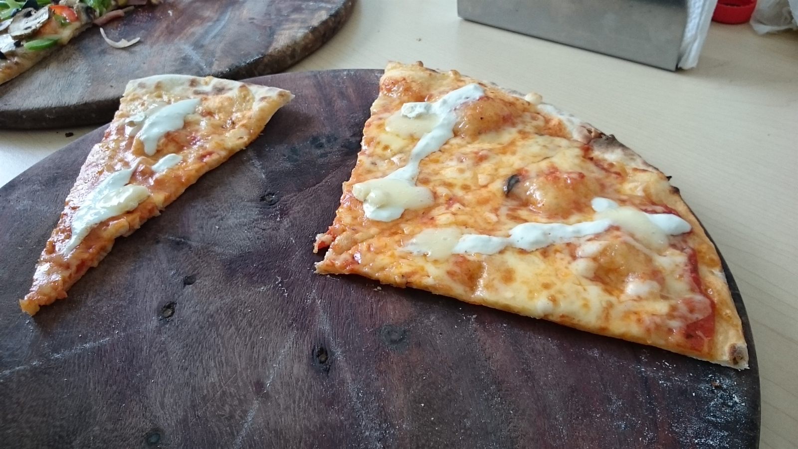 Dos rebanadas de pizza servidas sobre tabla de madera