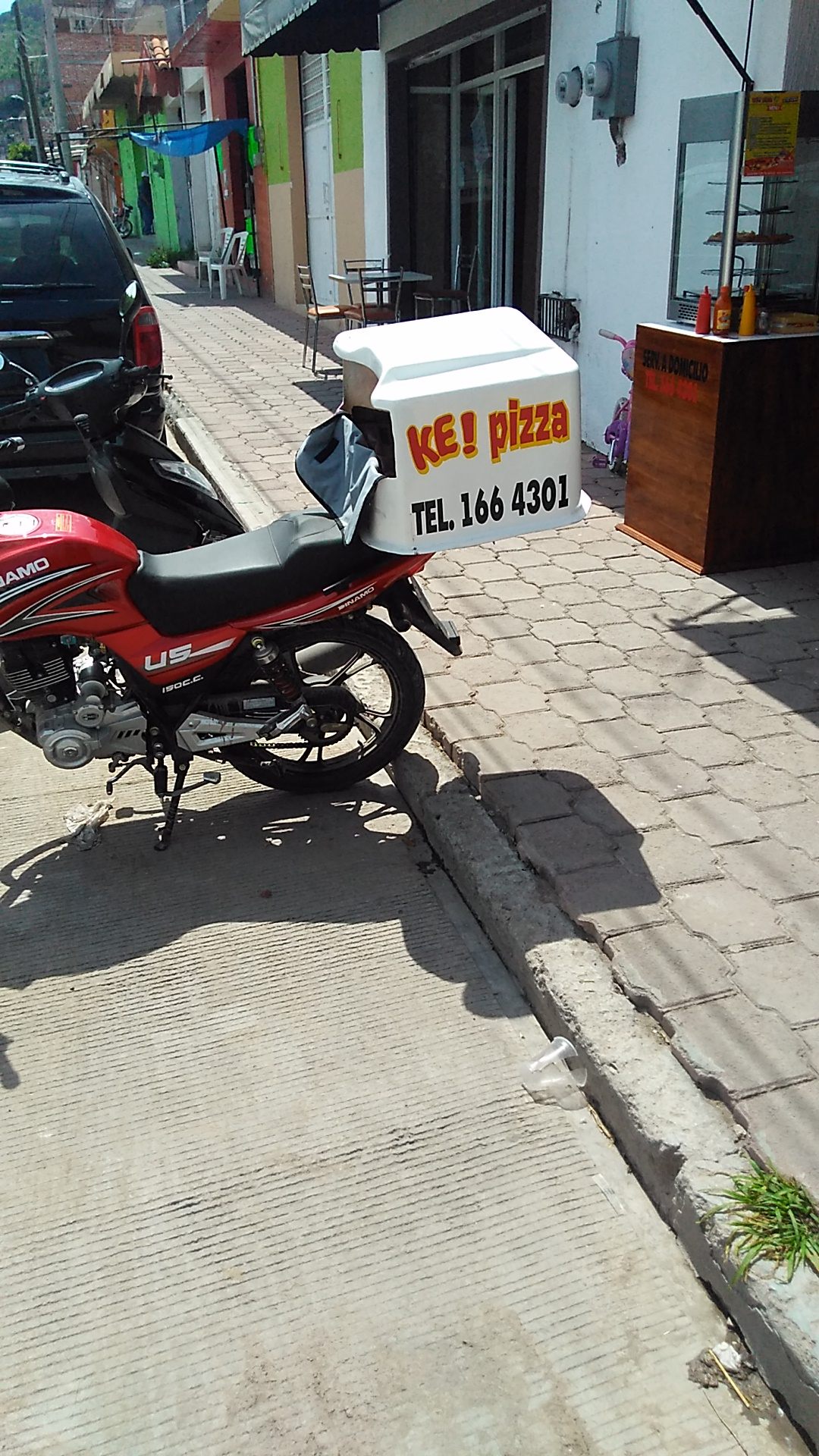 Moto de reparto de Ke Pizza con la caja térmica lista para salir a domicilio